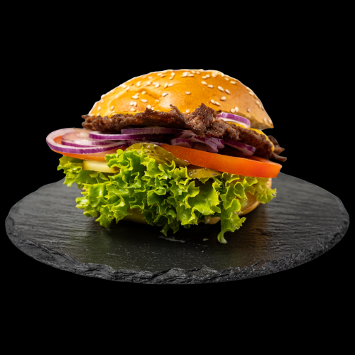 Ein Hamburger mit Salat, Tomate, roter Zwiebel und Rindfleischpatty in einem Sesambrötchen, dargestellt auf einer runden schwarzen Tafel vor schwarzem Hintergrund.