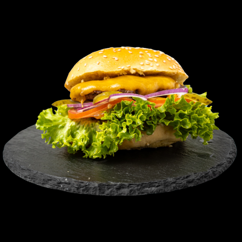 Ein Cheeseburger mit Salat, Tomaten, roten Zwiebeln, Essiggurken, geschmolzenem Käse und einem Sesambrötchen auf einem runden schwarzen Schieferbrett, isoliert auf einem schwarzen Hintergrund.